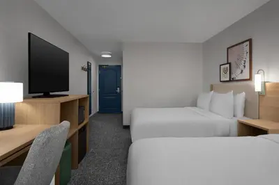 a hotel room with two beds and a flat screen tv at Spark by Hilton Washington Meadowlands Blvd in Washington