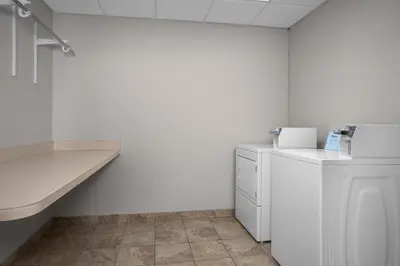 a white room with a washing machine and a counter at Spark by Hilton Washington Meadowlands Blvd in Washington
