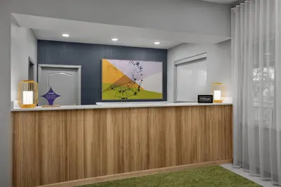 a lobby with a reception desk with two lamps at Spark by Hilton Washington Meadowlands Blvd in Washington