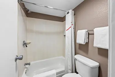 a bathroom with a white toilet and a shower at Red Roof Inn Columbus West - Hilliard in New Rome