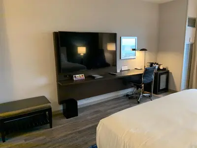 a hotel room with a bed and a desk with a television at Hyatt Regency Pittsburgh International Airport in Clinton