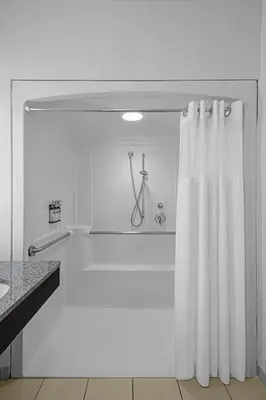 a white bathroom with a shower and a shower curtain at Hyatt Regency Pittsburgh International Airport in Clinton