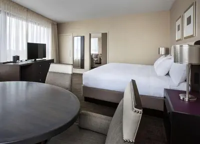 a hotel room with a large bed and a table at Hyatt Regency Pittsburgh International Airport in Clinton
