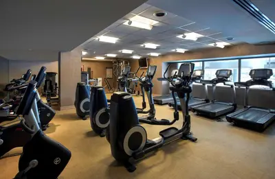 a gym with rows of treadmills and elliptical machines at Hyatt Regency Pittsburgh International Airport in Clinton