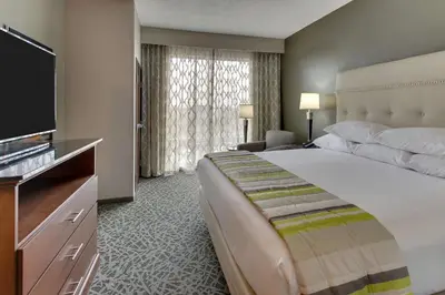 a hotel room with a large bed and a flat screen tv at Drury Inn & Suites Columbus Polaris in Columbus