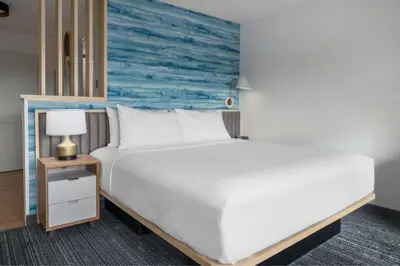 a bedroom with a bed and a night stand with a lamp at TownePlace Suites by Marriott Sidney in Sidney