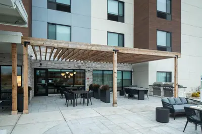 a wooden pergola on a patio in front of a building at TownePlace Suites by Marriott Sidney in Sidney
