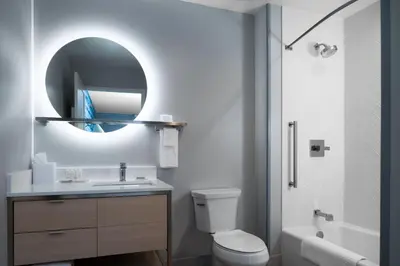 a bathroom with a toilet and a sink and a mirror at TownePlace Suites by Marriott Sidney in Sidney