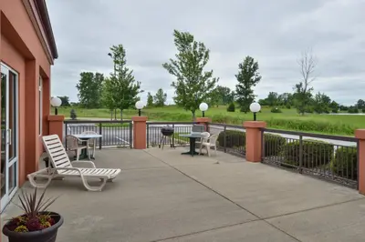 a patio with chairs and tables and a fence at Red Roof Inn Clyde in Clyde