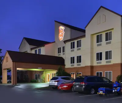 a hotel with cars parked in a parking lot at Red Roof Inn Clyde in Clyde