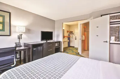 a hotel room with a bed and a desk and a television at La Quinta Inn by Wyndham Toledo Perrysburg in Perrysburg