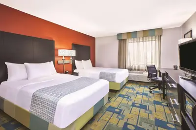 a hotel room with two beds and a flat screen tv at La Quinta Inn by Wyndham Toledo Perrysburg in Perrysburg