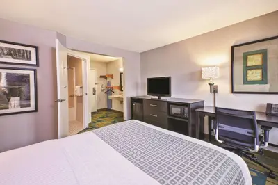 a hotel room with a bed and a desk and a television at La Quinta Inn by Wyndham Toledo Perrysburg in Perrysburg