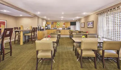 a restaurant with tables and chairs and a bar at La Quinta Inn by Wyndham Toledo Perrysburg in Perrysburg