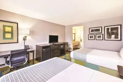 a hotel room with two beds and a desk with a computer at La Quinta Inn by Wyndham Toledo Perrysburg in Perrysburg