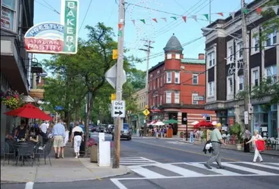 a busy city street with people crossing the street at Short Term Rentals Little Italy Cleveland in Cleveland