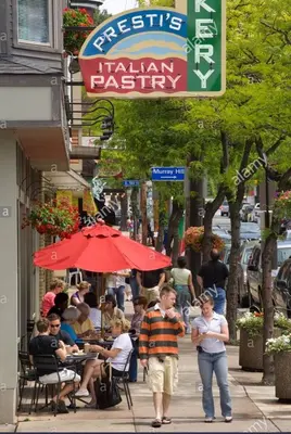 a group of people walking down a sidewalk near a restaurant at Short Term Rentals Little Italy Cleveland in Cleveland