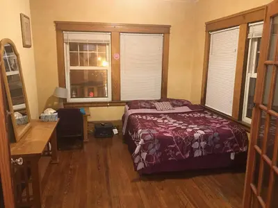 a bedroom with a bed and a desk and windows at Short Term Rentals Little Italy Cleveland in Cleveland