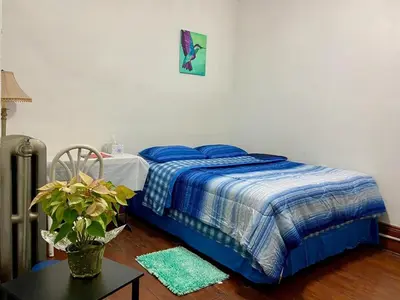 a bedroom with a bed with blue sheets and a table at Short Term Rentals Little Italy Cleveland in Cleveland