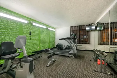 a gym with exercise equipment and a green wall at La Quinta by Wyndham Cleveland Macedonia in Macedonia