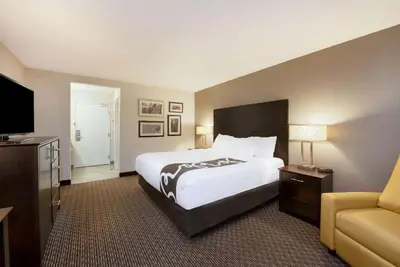 a hotel room with a large bed and a couch at La Quinta by Wyndham Cleveland Macedonia in Macedonia