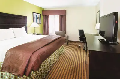 a hotel room with a bed and a flat screen tv at La Quinta by Wyndham Columbus - Grove City in Grove City