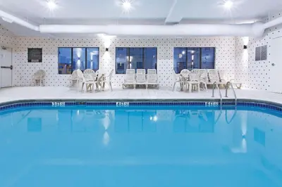 a large swimming pool with chairs and tables in a building at La Quinta by Wyndham Columbus - Grove City in Grove City