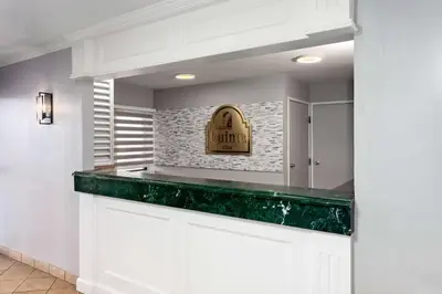 a kitchen with white cabinets and a green counter top at La Quinta Inn by Wyndham Cleveland Independence in Independence