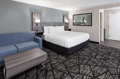 a hotel room with a bed and a couch at La Quinta Inn by Wyndham Cleveland Independence in Independence