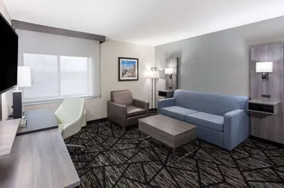 a hotel room with a couch and a chair at La Quinta Inn by Wyndham Cleveland Independence in Independence