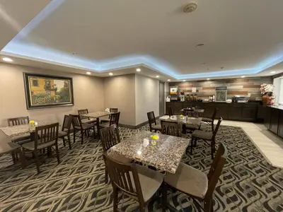 a restaurant with tables and chairs and a kitchen at La Quinta Inn and Suites by Wyndham Cincinnati North in Springdale