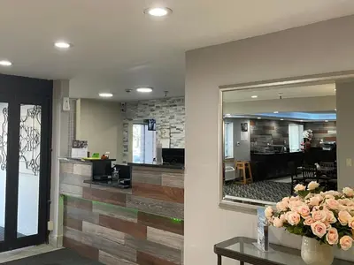 a lobby with a mirror and flowers on a table at La Quinta Inn and Suites by Wyndham Cincinnati North in Springdale