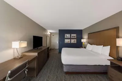 a hotel room with a bed and a flat screen tv at Comfort Inn & Suites Tipp City Dayton North I-75 in Tipp City