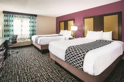 a hotel room with two beds and a desk at La Quinta by Wyndham Cincinnati NE - Mason in Mason