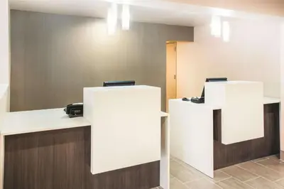 a waiting room with two white reception desks at La Quinta by Wyndham Cincinnati NE - Mason in Mason