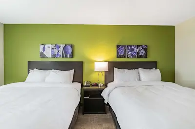 two beds in a room with green walls at Sleep Inn & Suites Mt Hope near Auction & Event Center in Millersburg