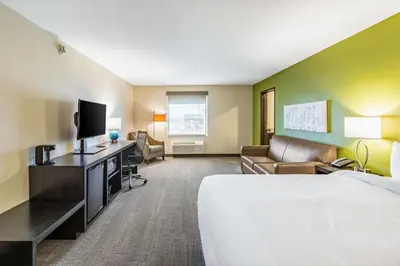 a hotel room with a bed and a desk with a television at Sleep Inn & Suites Mt Hope near Auction & Event Center in Millersburg