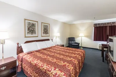 a hotel room with a bed and a chair at Quality Express Inn & Suites in Mineralwells