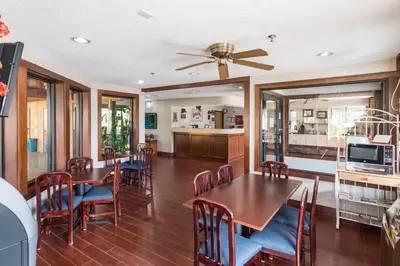a dining room with tables and chairs and a ceiling fan at Quality Express Inn & Suites in Mineralwells