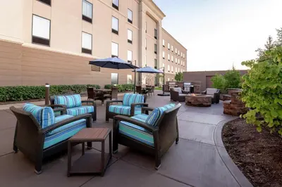 a patio with chairs and tables and an umbrella at Hampton Inn & Suites Wheeling - The Highlands in Triadelphia