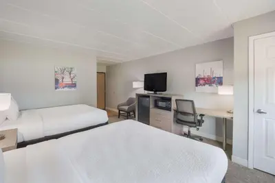 a hotel room with two beds and a desk with a tv at Best Western Fort Wayne I-69 North in Fort Wayne