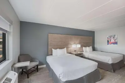 a hotel room with two beds and a chair at Best Western Fort Wayne I-69 North in Fort Wayne