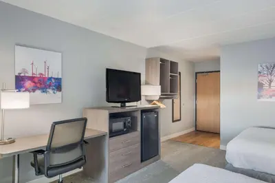a room with a bed and a desk with a television at Best Western Fort Wayne I-69 North in Fort Wayne