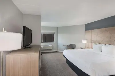 a hotel room with a bed and a flat screen tv at Best Western Fort Wayne I-69 North in Fort Wayne