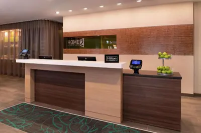 a hotel lobby with a large counter with a phone on it at Home2 Suites By Hilton New Albany Columbus in New Albany