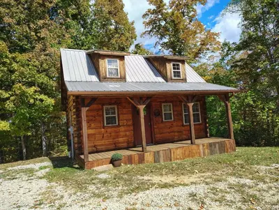 a small log cabin with a tin roof at The Hampton - An Amish Built Deluxe Log Cabin in Genoa