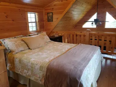a bedroom with a bed in a cabin at The Hampton - An Amish Built Deluxe Log Cabin in Genoa