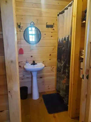a bathroom with a sink and a mirror at The Genoa - An Amish Built Deluxe Cabin in Genoa