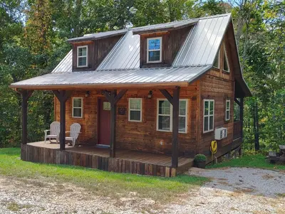 a log cabin with a porch and a metal roof at The Frontier - An Amish Built Deluxe Cabin in Genoa