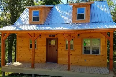 a cabin with a tin roof on a deck at The Frontier - An Amish Built Deluxe Cabin in Genoa